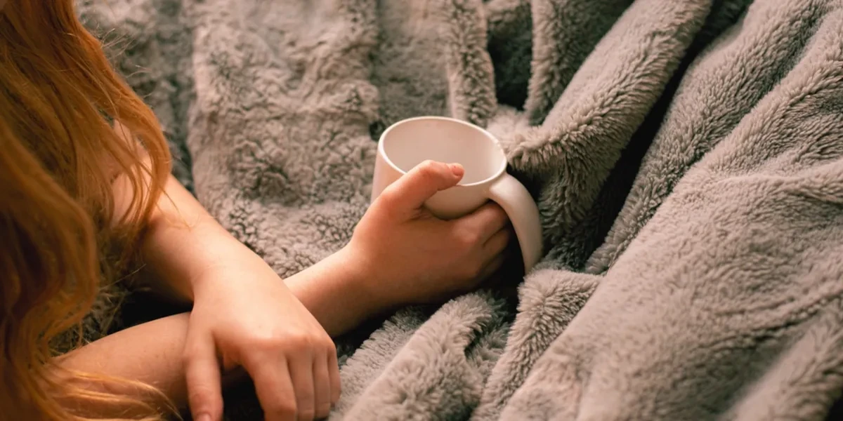 A calm hand holding a soothing cup with neutral tone to symbolize emotional safety and comfort culture in modern psychotherapy