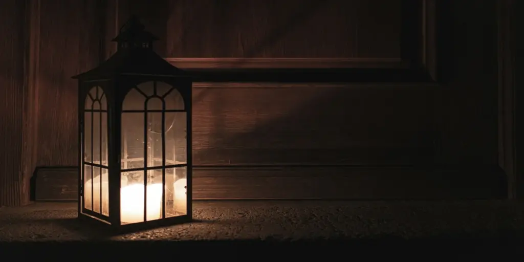 A lit lantern casting a soft light in a dark wooden interior, suggesting therapy in the age of AI as guidance in uncertainty 